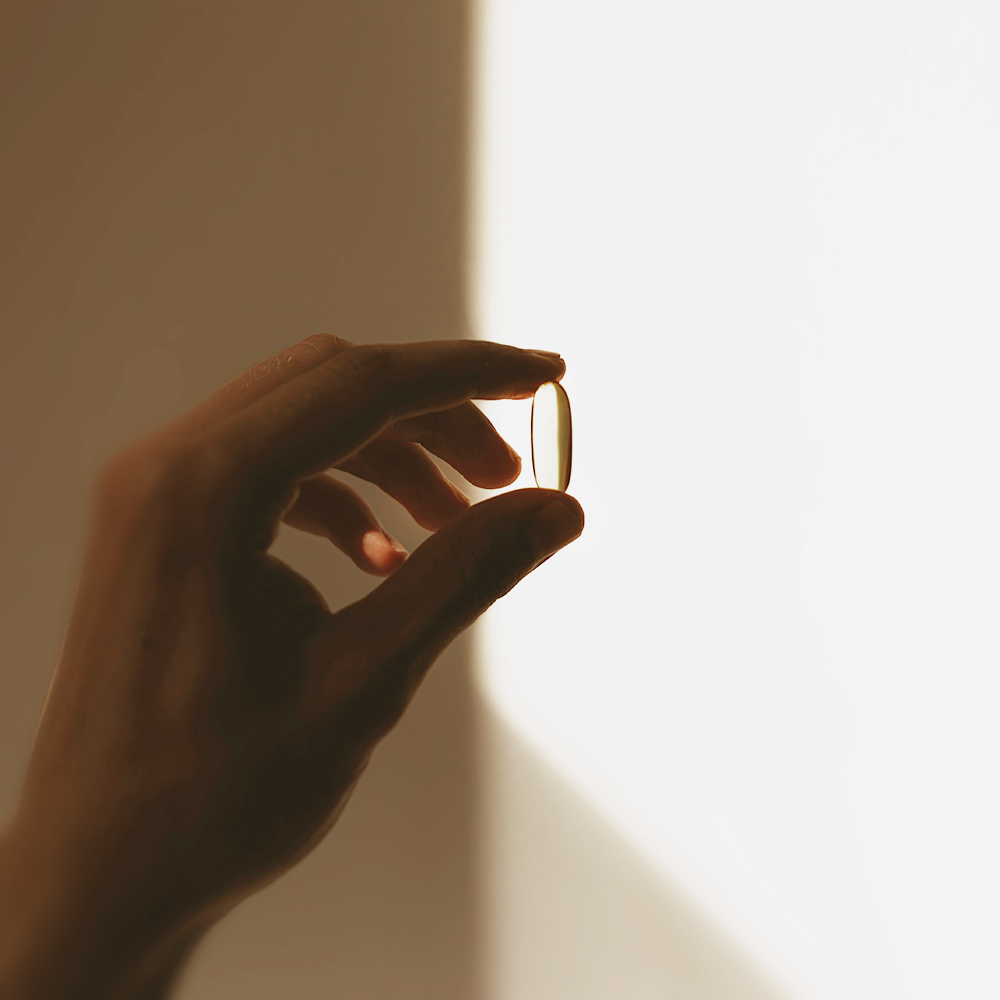 Kapsel in der Hand Schattenspiel im Hintergrund